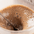 Primer plano de bebida Zenergy Chocolate Belga mezclándose con textura espumosa