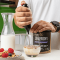 Preparación de Zenergy Espresso Intenso con leche y espumador manual en vaso de cristal